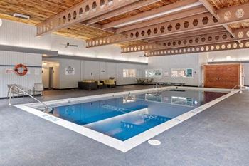 a large pool in a large room with a wooden ceiling